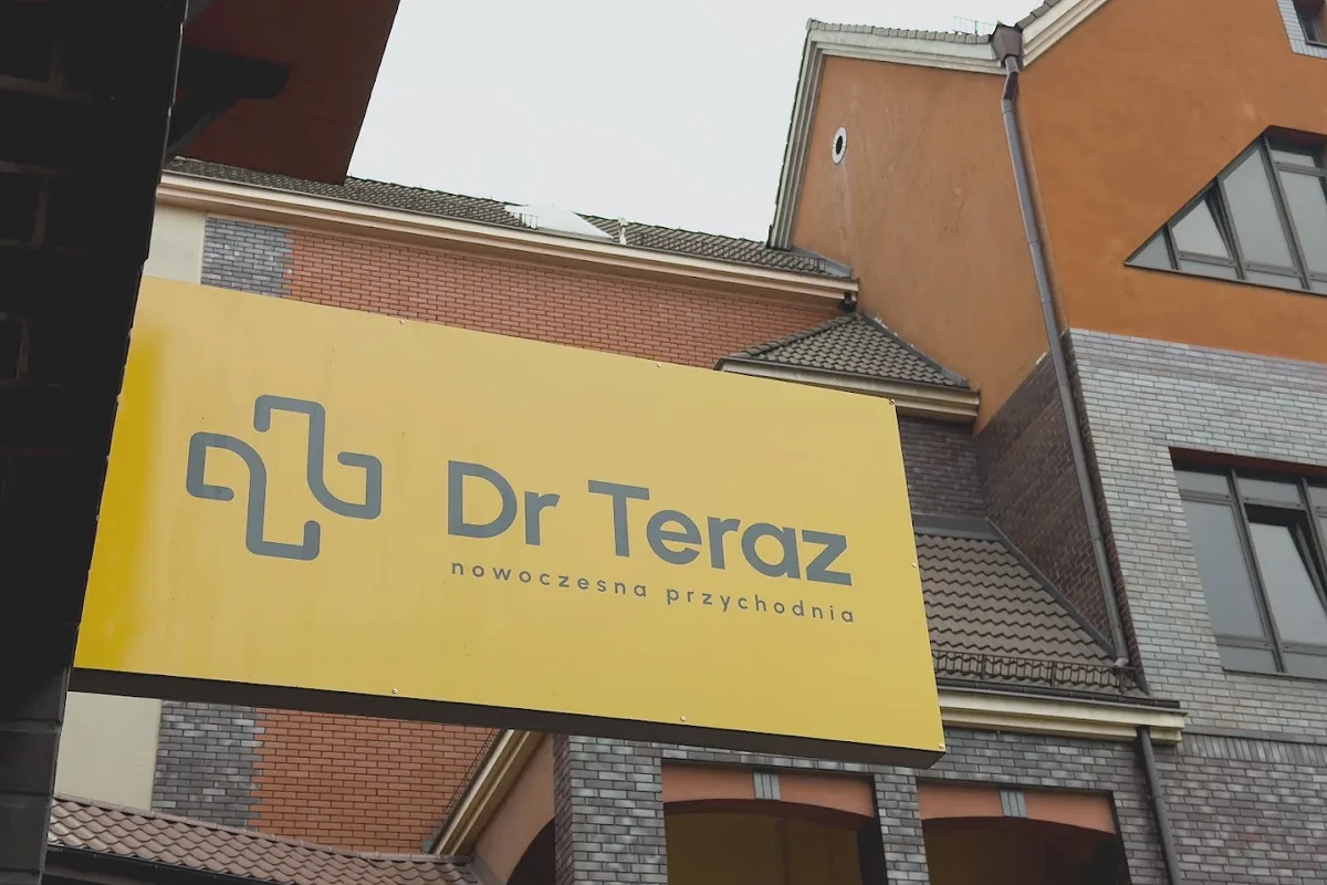 Żółty szyld Dr Teraz nad wejściem do przychodni na Białołęce